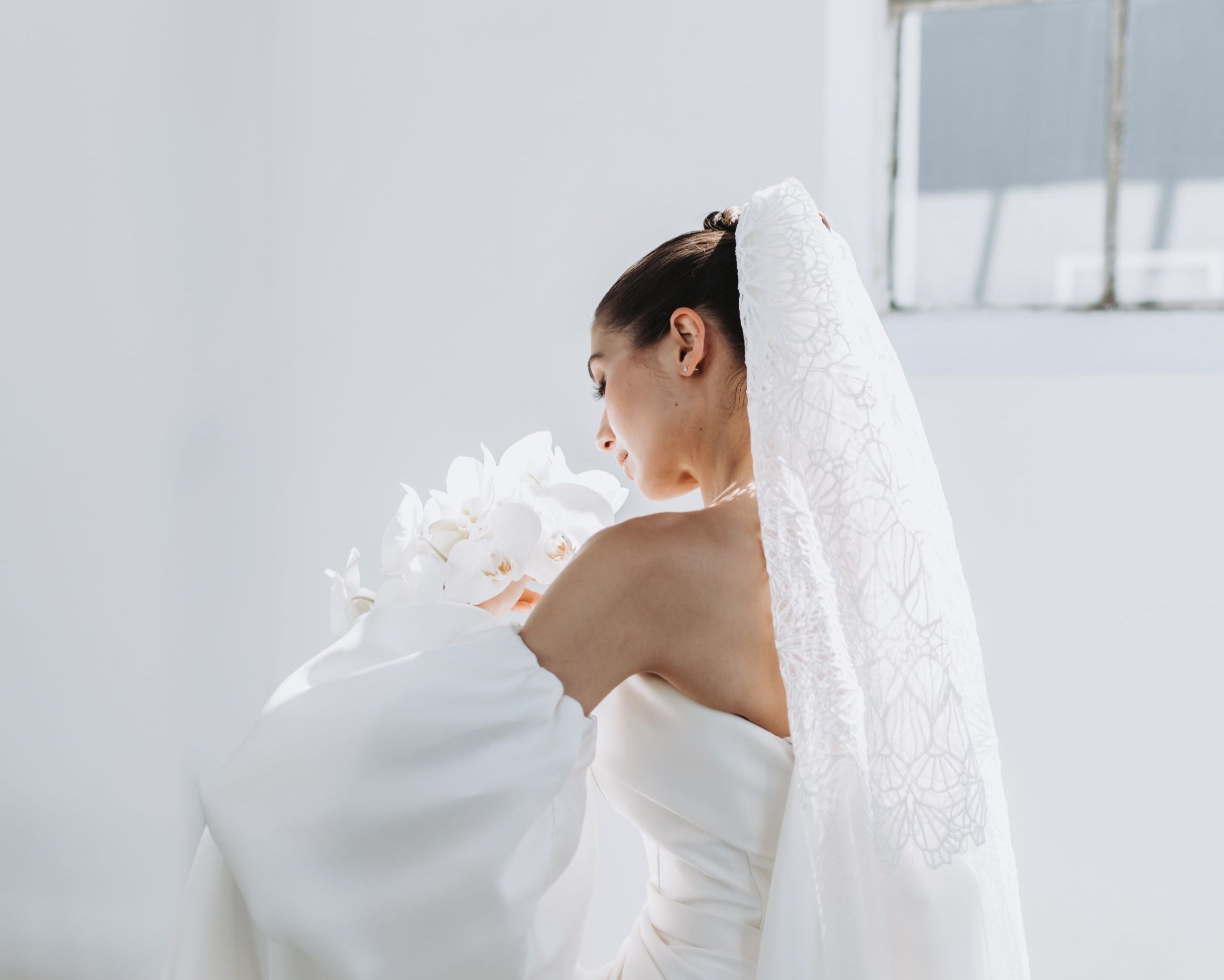 Eine Braut mit einem cleanen Look mit Schleier, seitenansicht