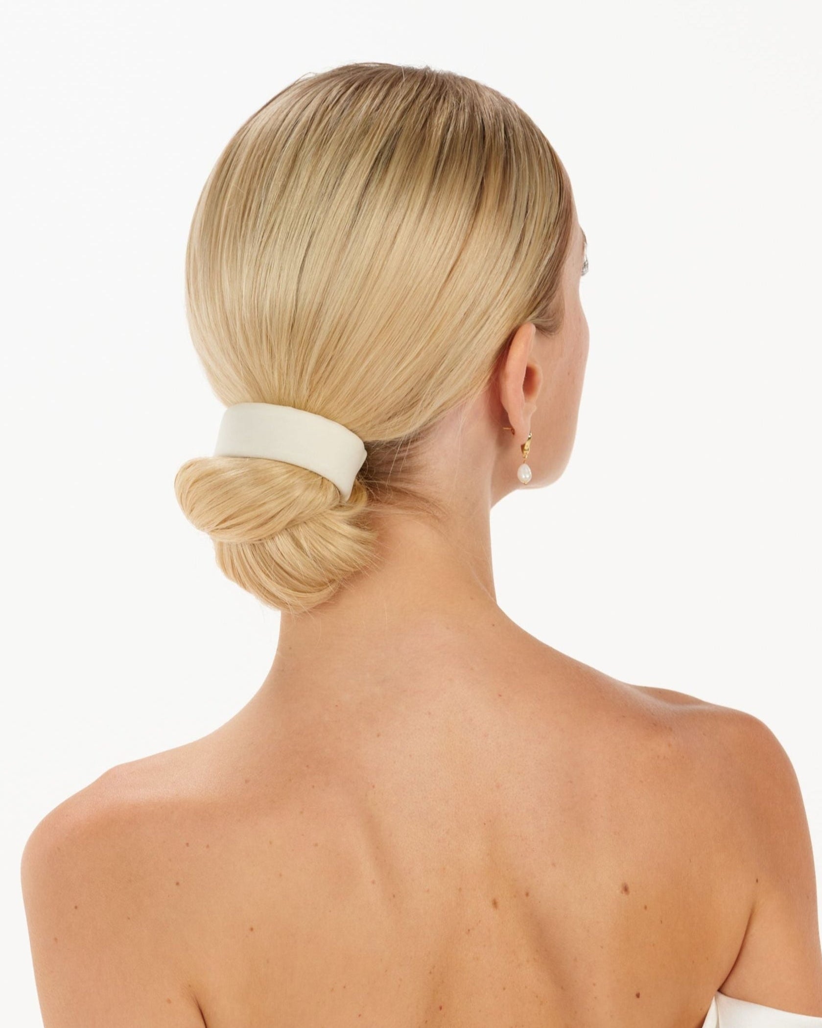 Eine Braut trägt ein cleanes Tüll-Haarband am Bun