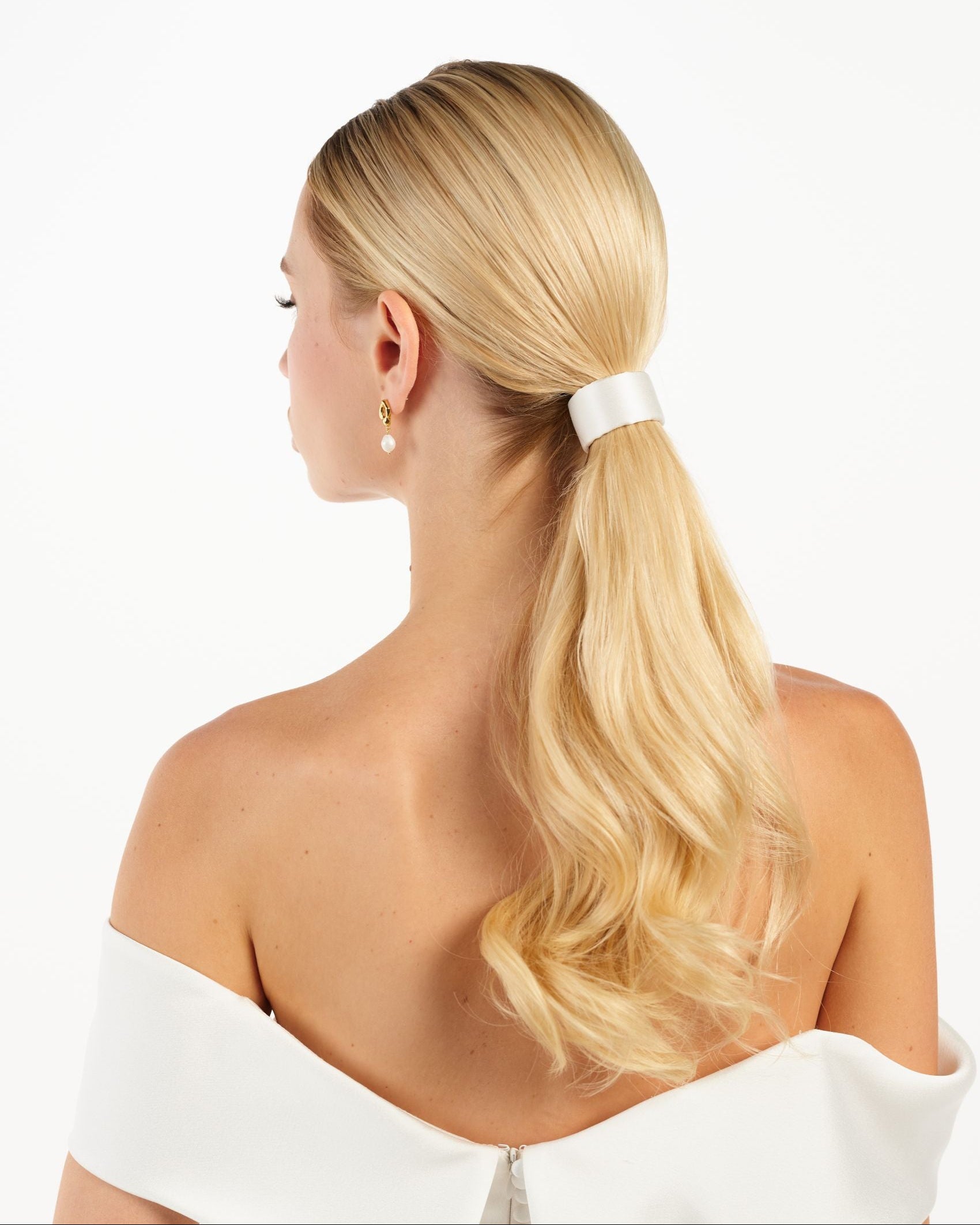 Eine Braut mit einem cleanen Seiden-Haarband im Bun