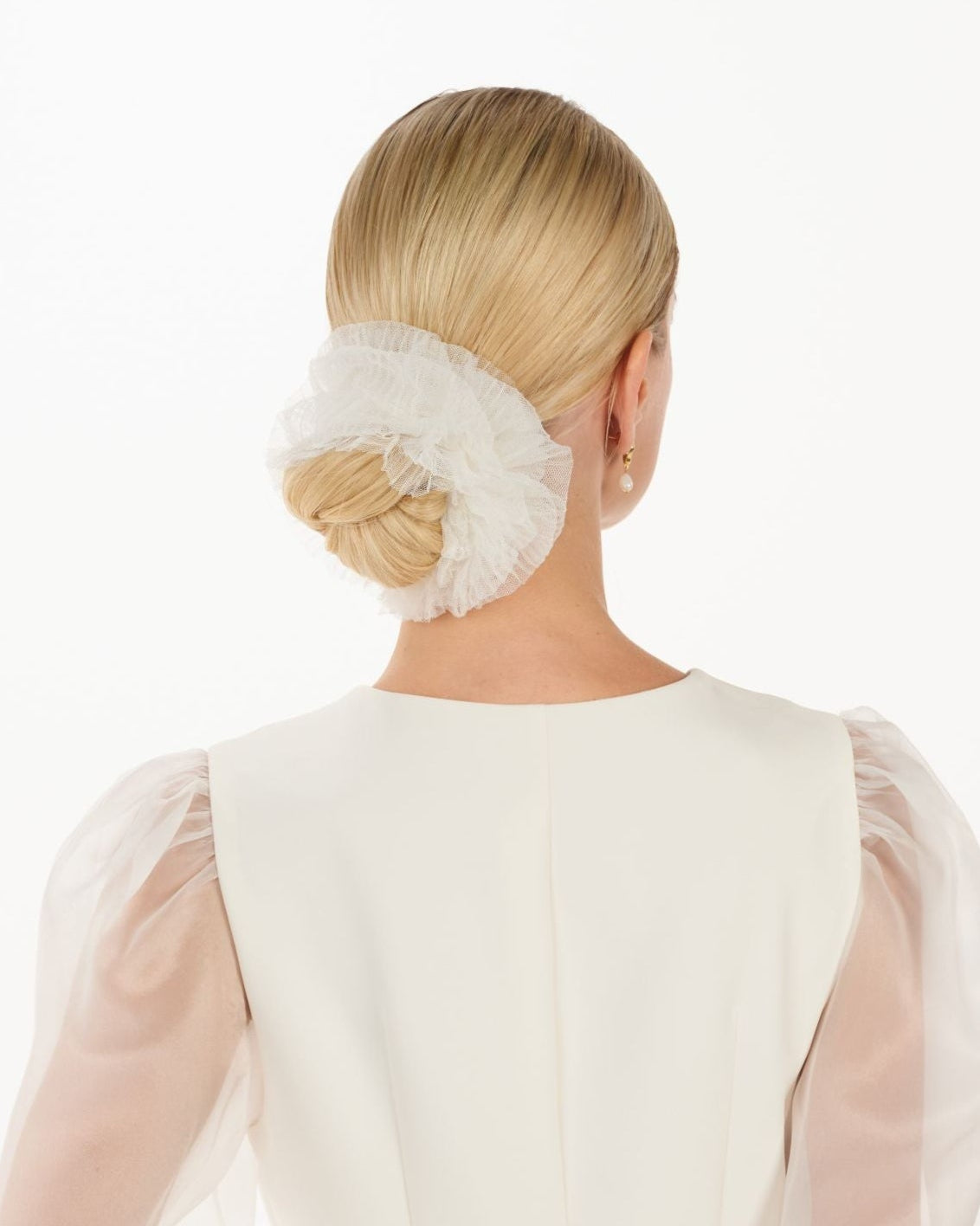 Eine Braut mit einem gerafften Tüll-Haarband im Bun