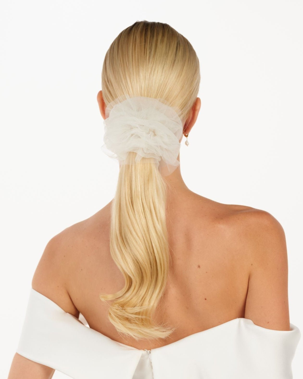 Eine Braut mit einem gerafften Tüll-Haarband im Ponytail