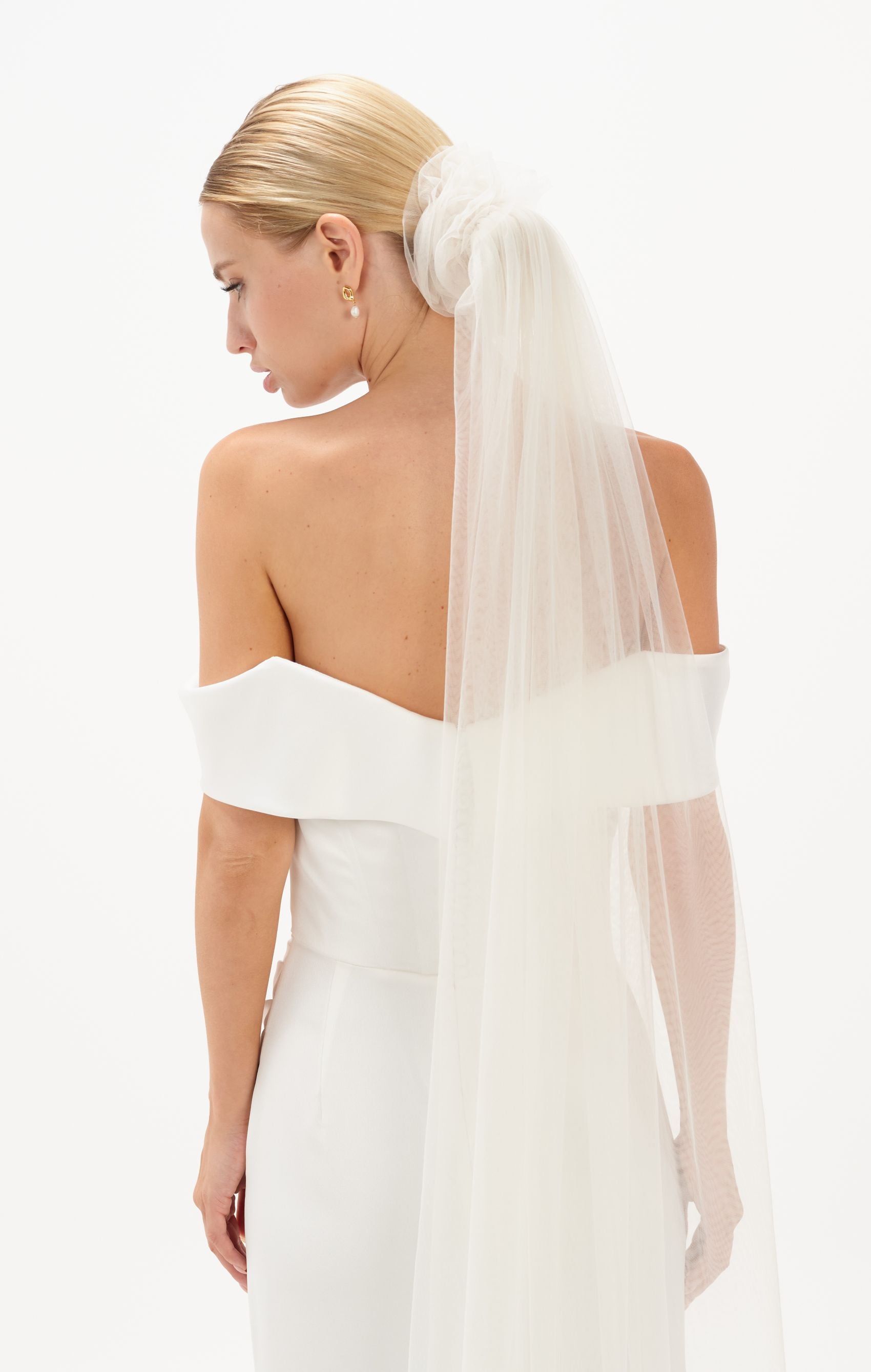 Eine Braut mit gerafften Tüll-Haarband und Schleier im Bun, hinteransicht