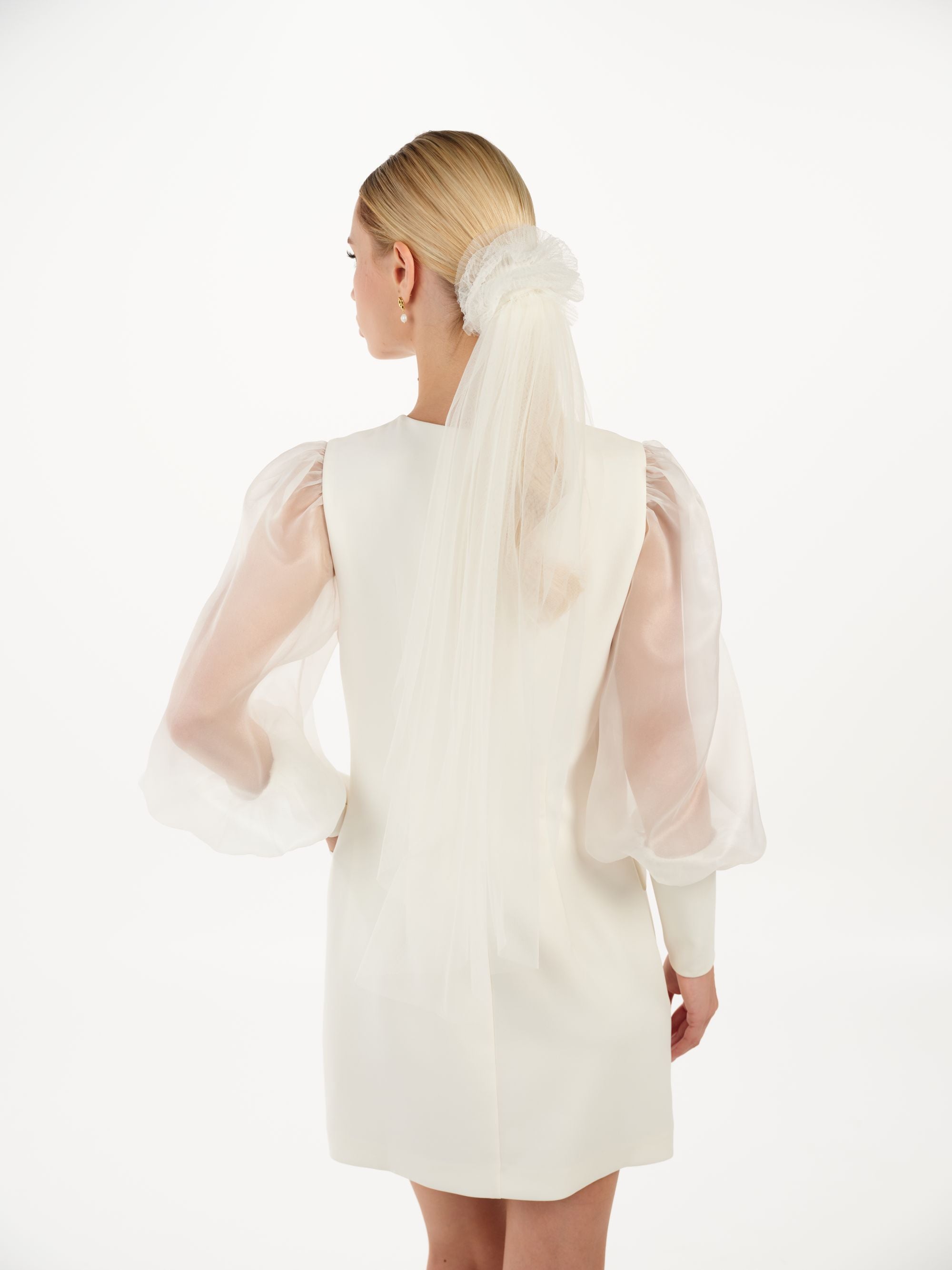 Eine moderne Braut mit gerafften Tüll-Haarband und kurzem Schleier, hinteransicht