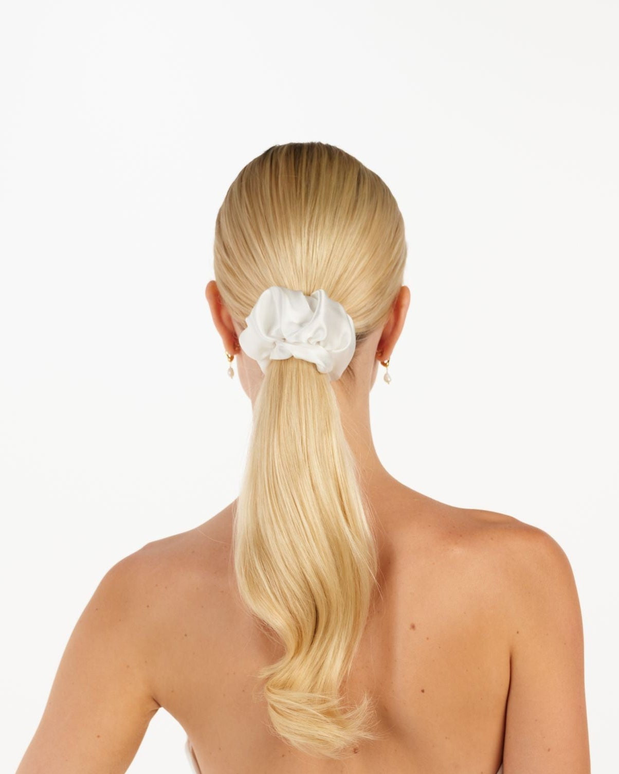 Eine Braut mit einem gerafften Tüll-Haarband im Ponytail, hinteransicht