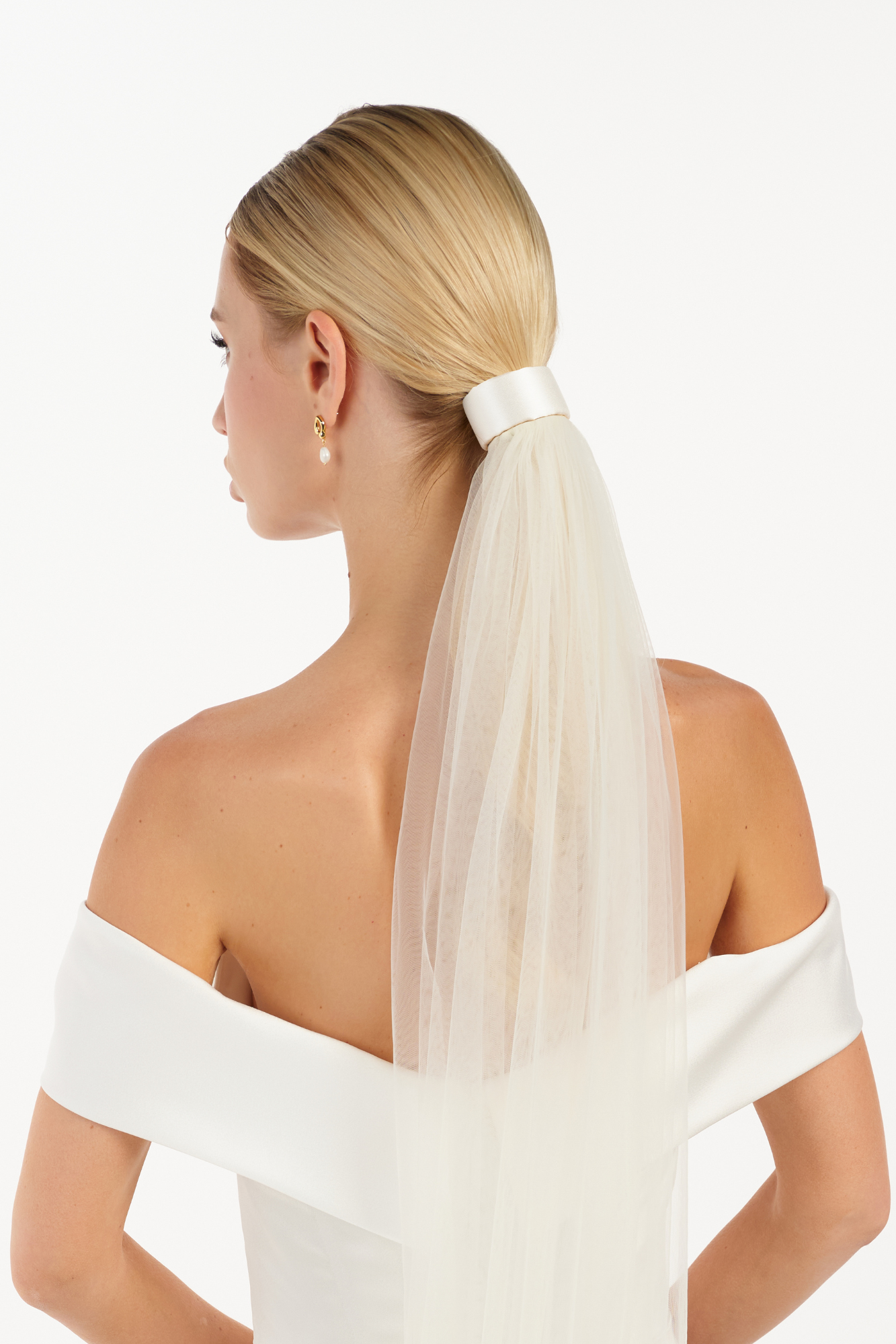 Eine Braut trägt ein Seiden-Haarband & Schleier im Bun, hinteransicht