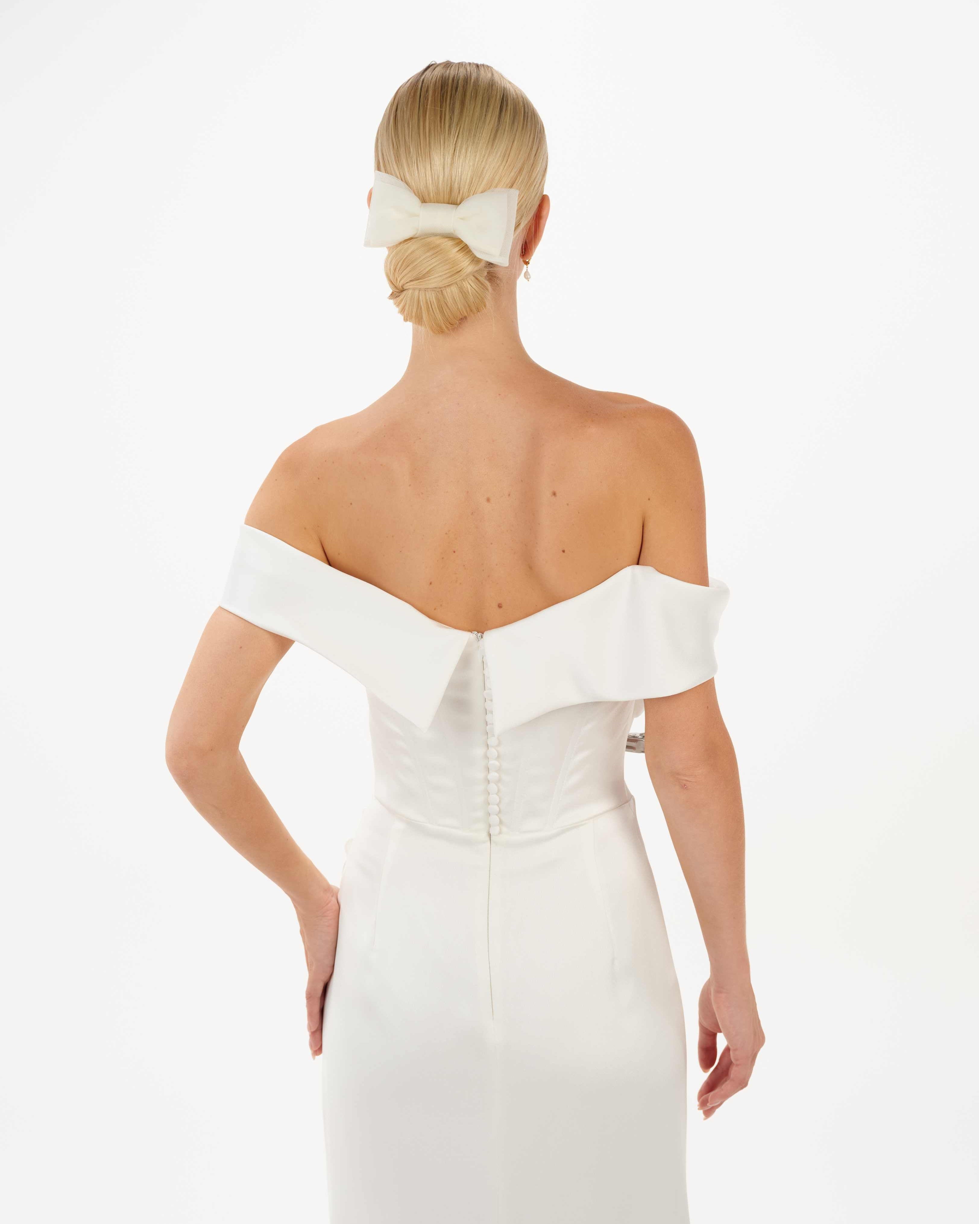 EIne Braut mit cleanen Bundund cleanen Kleid trägt eine Tüllschleife