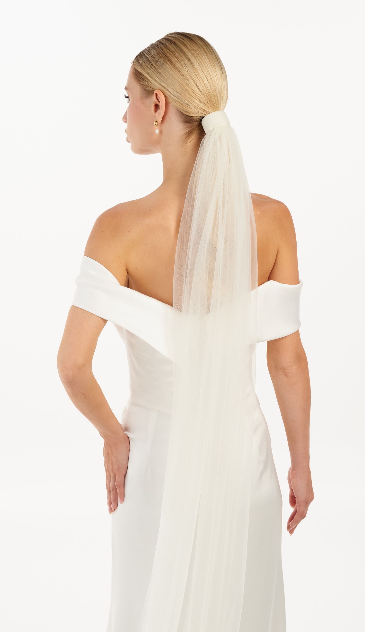 Eine Braut mit Tüll-Haarband und Schleier, hinteransicht