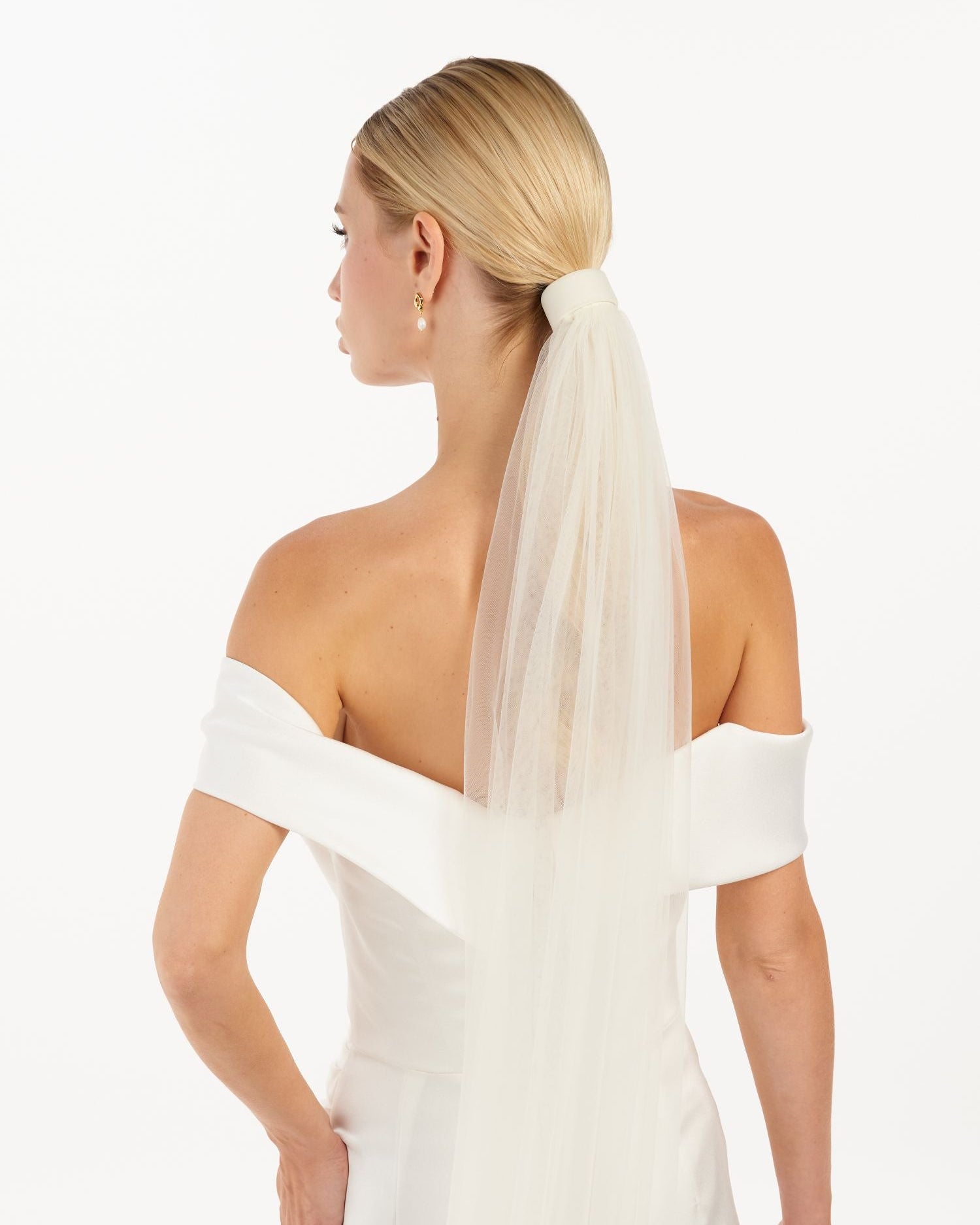 Eine Braut mit Tüll-Haarband und Schleier, hinteransicht