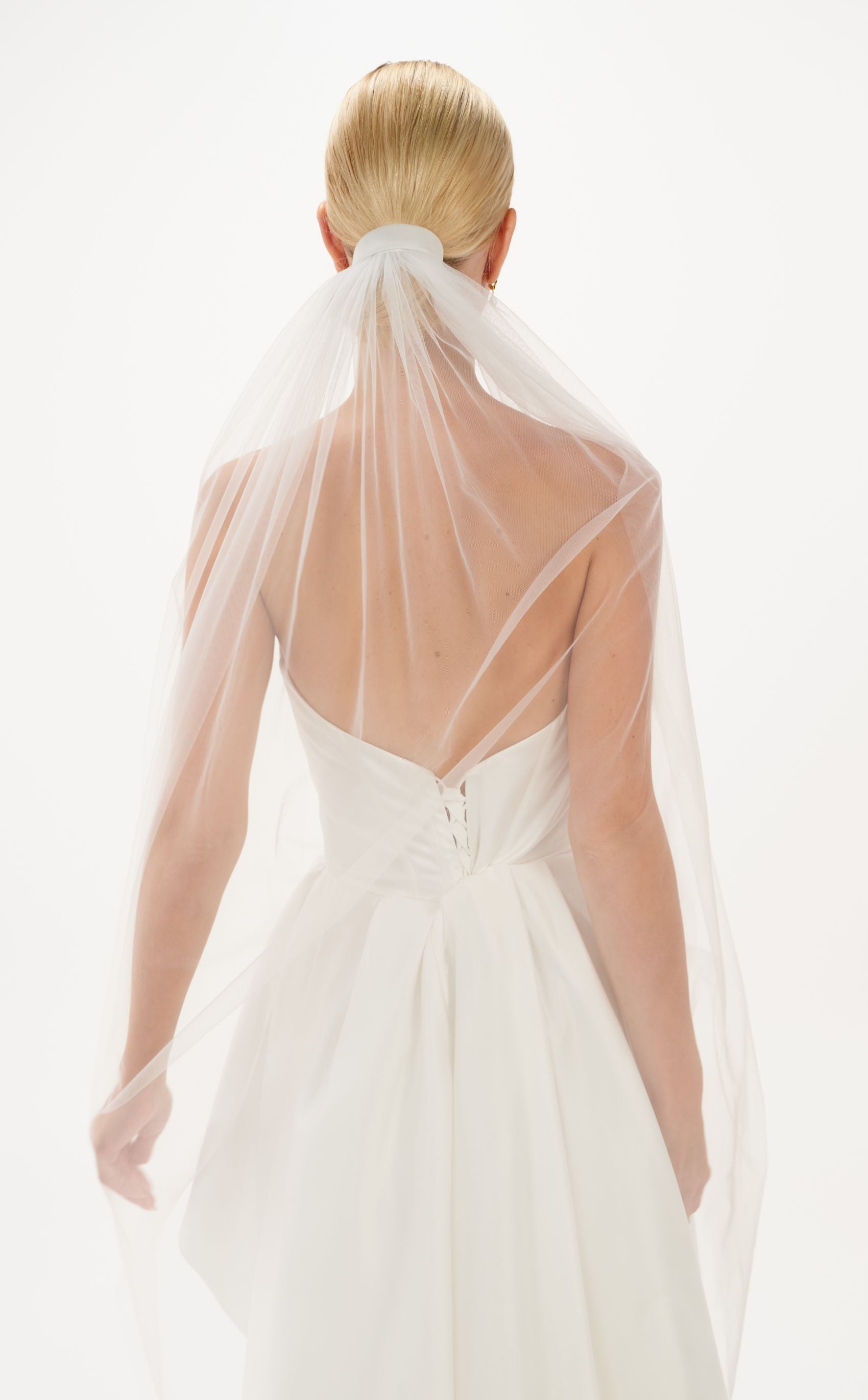 Eine Braut mit Tüll-Haarband & Schleier im Bun, hinteransicht