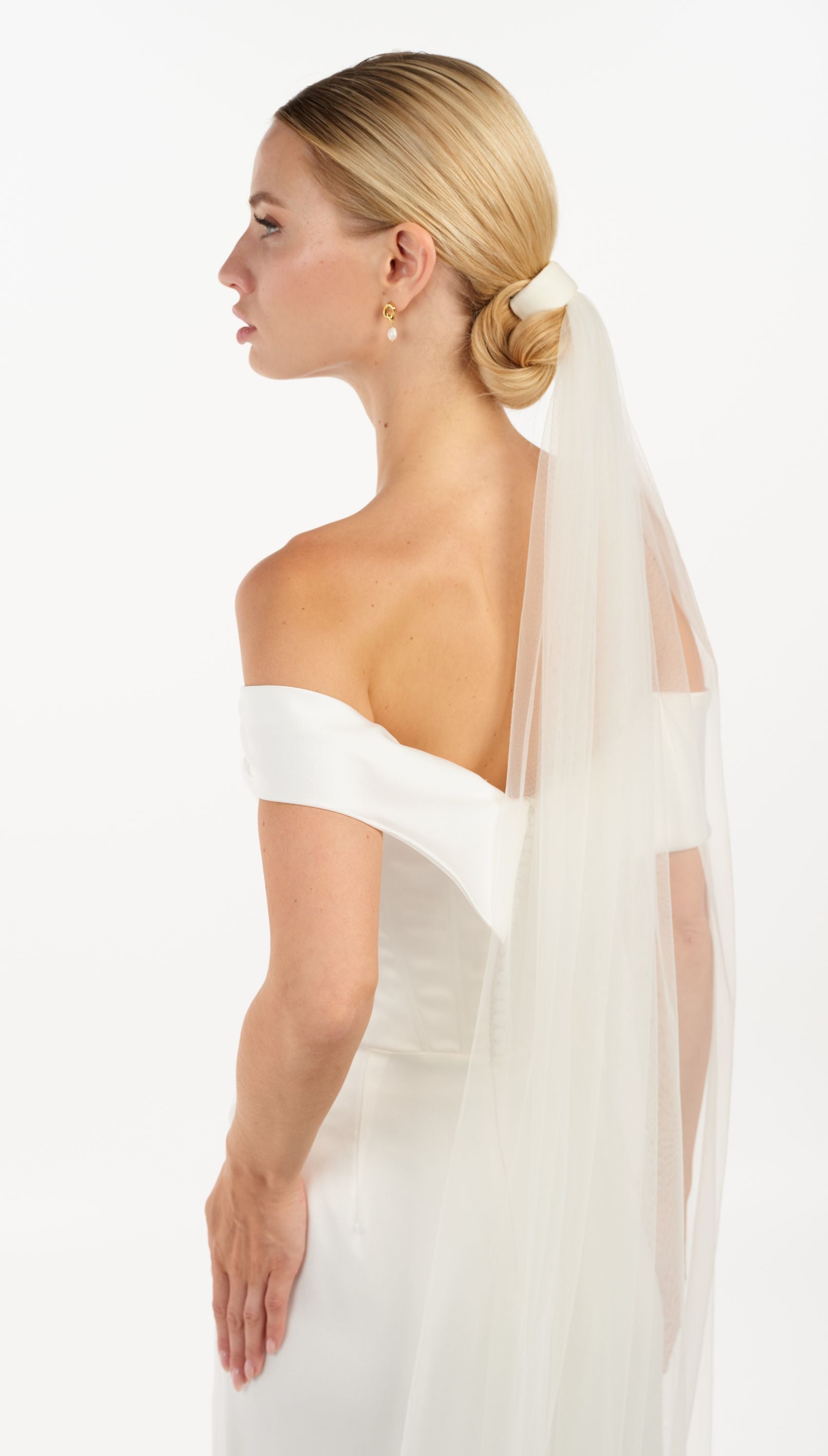 Eine Braut mit Tüll-Haarband + Schleier im Bun, seitenansicht