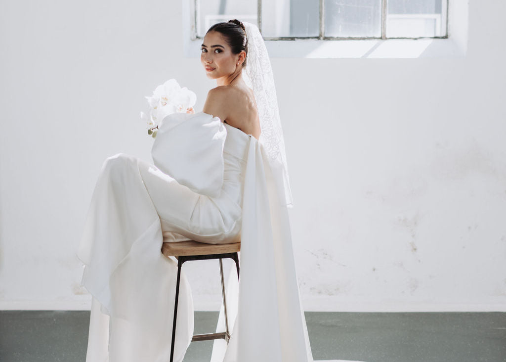 Eine Braut mit cleaner Frisur und Schleier