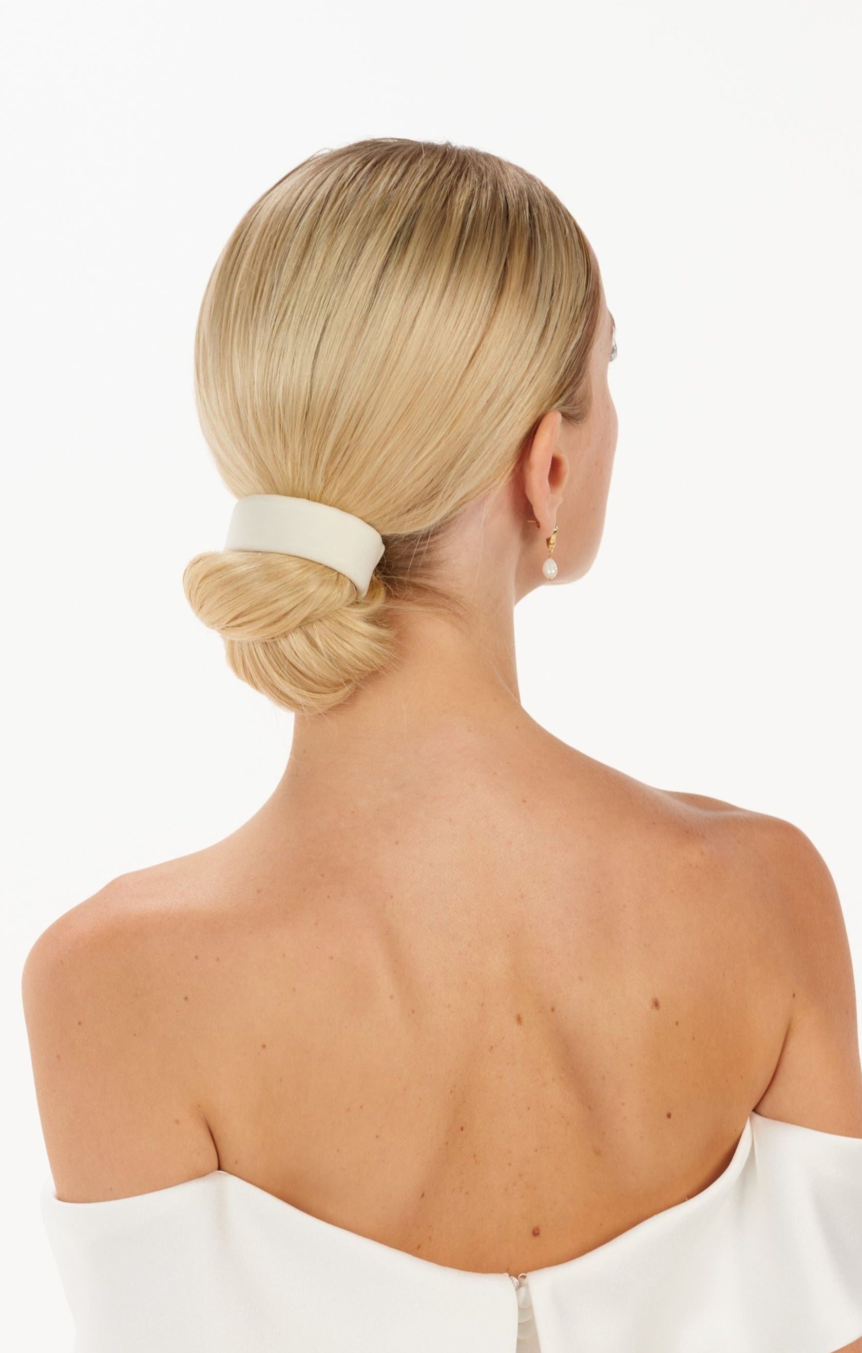 Eine Braut trägt ein cleanes Tüll-Haarband am Bun