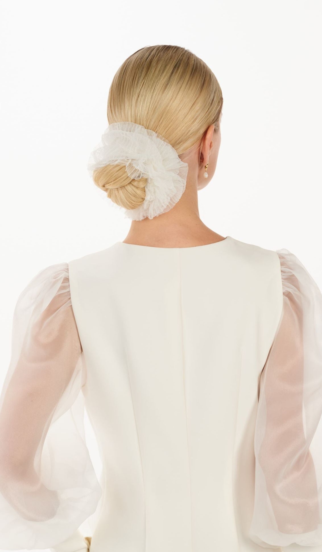 Eine Braut mit einem gerafften Tüll-Haarband im Bun