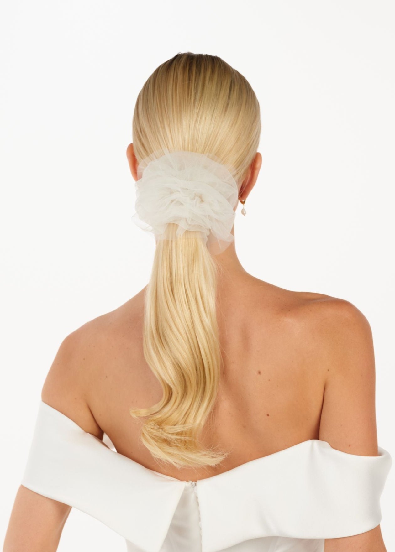 Eine Braut mit einem gerafften Tüll-Haarband im Ponytail