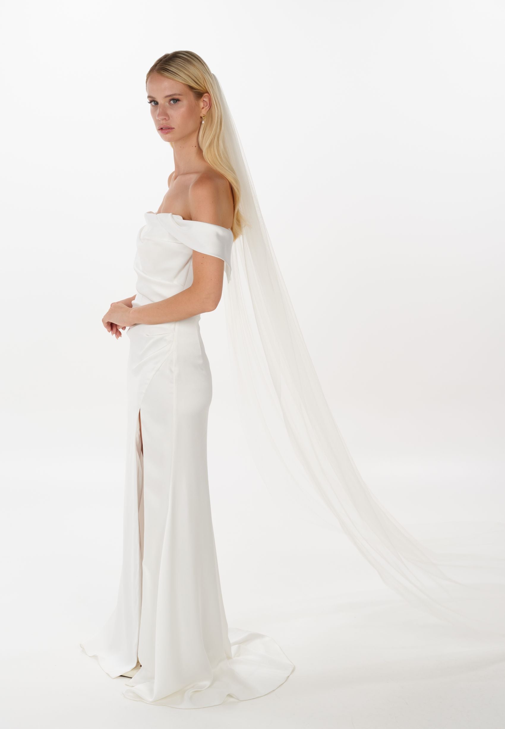 Eine Braut mit offenen Haaren trägt einen langen Schleier, seitenansicht