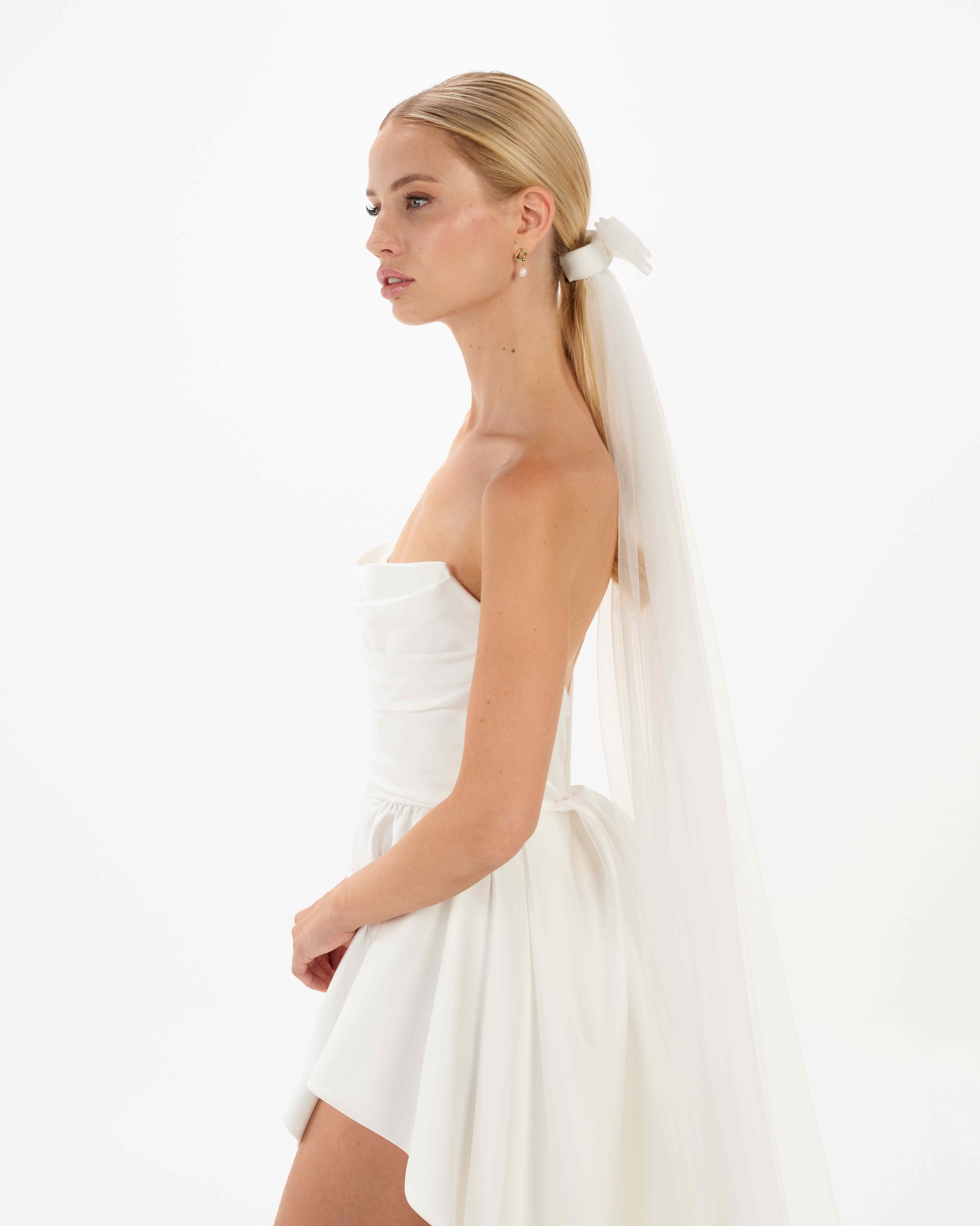 EIne Braut mit Ponytail trägt  eine Tüllschleife, Tüllhaarband und einen Schleier