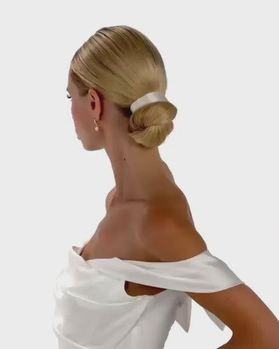 Eine Braut mit cleanen Bun und Seiden-Haarband dreht von hinten nach vorne
