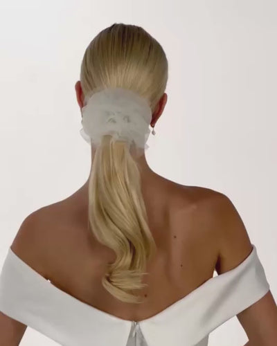 Eine Braut mit Ponytail und welligen Tüll-Haarband dreht von hinten nach hinten