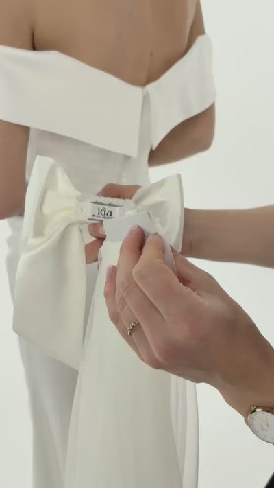 Ein magnetischer Schleier wird an eine Seidenschleife gepinnt und an der Brautfrisur befestigt