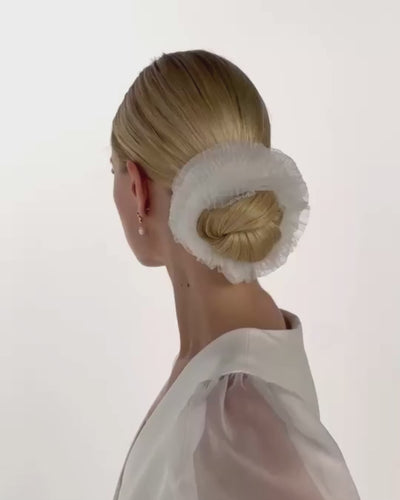 Eine Braut mit Bun und welligen Tüll-Haarband dreht von hinten nach vorne