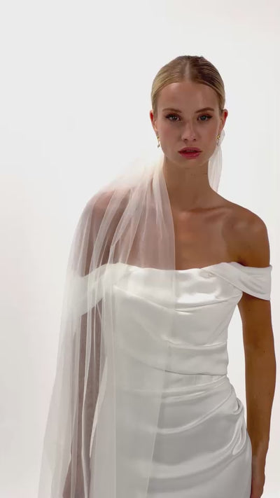 Eine Braut mit gerafften Seiden-Haarband und Schleier dreht sich von vorne nach hinten