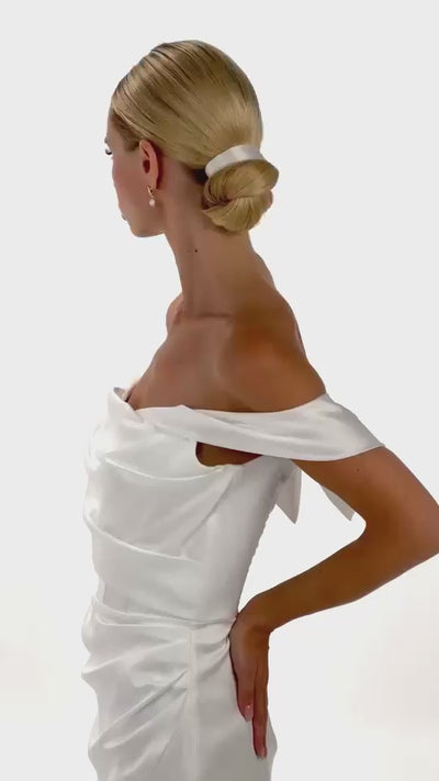 Eine Braut mit Seiden-Haarband in der Frisur dreht sich von hinten nach vorne